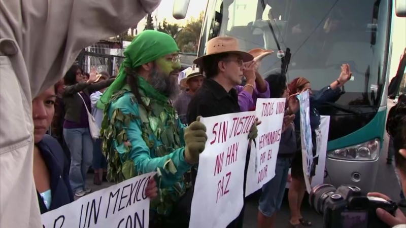Several people protest in front of a bus