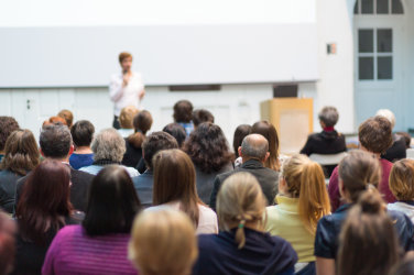 Conference room. Audience looks at a speaker.