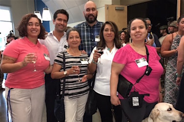 Lobby. Judy Matthews, from Lighthouse, and 5 people from Dicapta stand together smiling.