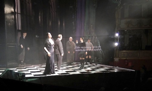 Theater. The Addams Family scene. Subtitles appear on a transparent lectern.