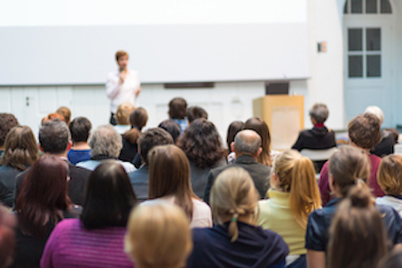 Conference room. Audience looks at a speaker.