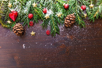 Christmas ornament with pine branches and cones, stars and hearts over brown wood