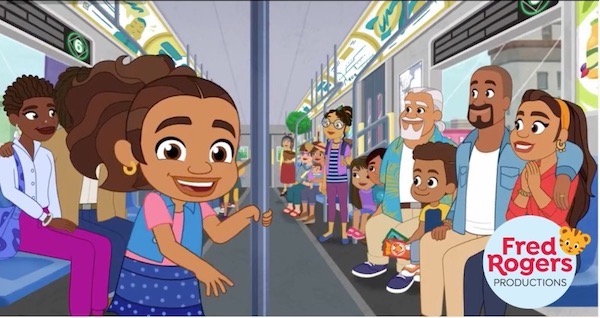 Alma stands inside a subway car. She grabs a pole located in the middle of the car. In front of her, her family is seated next to a window.