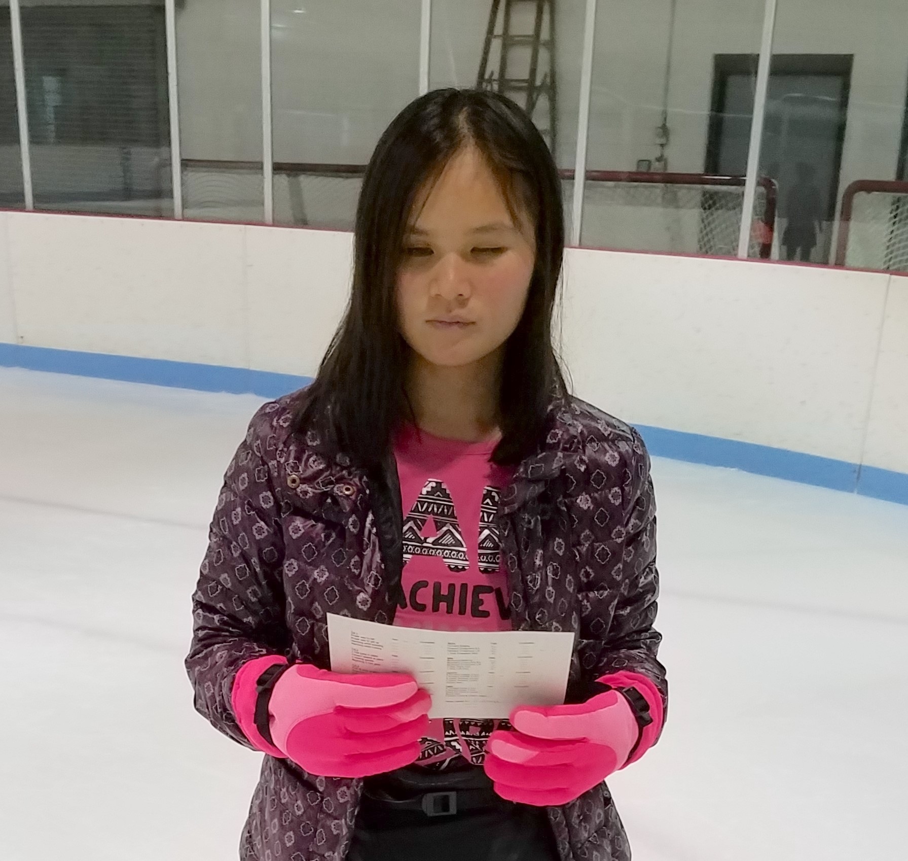 A girl in winter gear on an ice skating ring