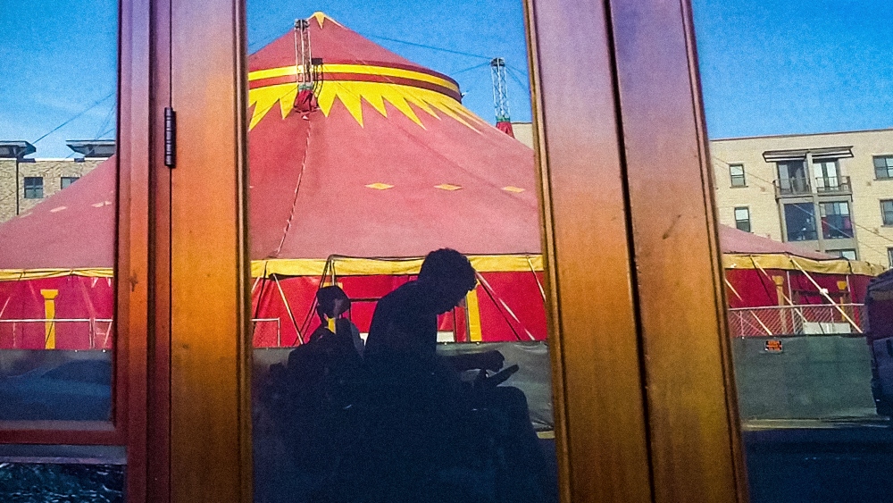 a shadow of a man in a wheelchair projects in a tent