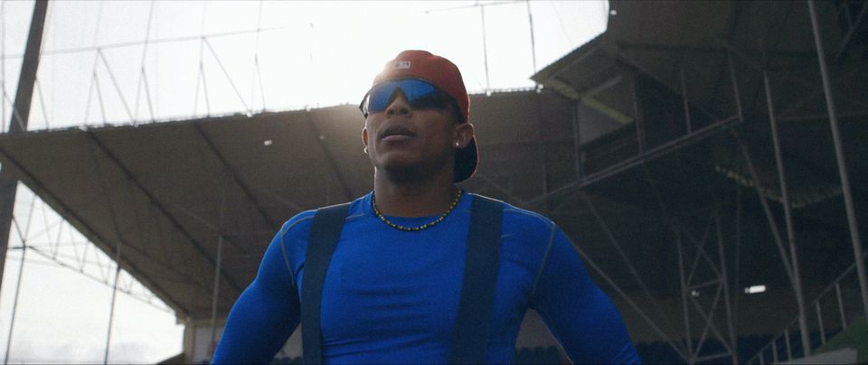a man in sunglasses and a baseball cap faces the sun