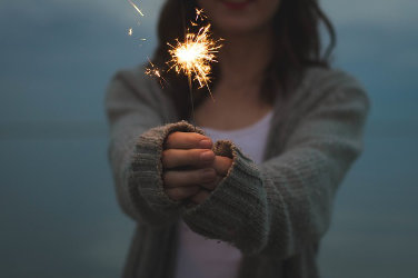 A woman holds a sparkling candle