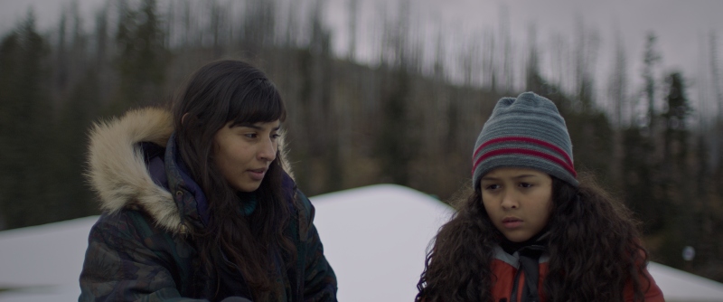 a woman stands in the snow with her daughter