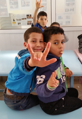 Kids doing ASL in a classroom