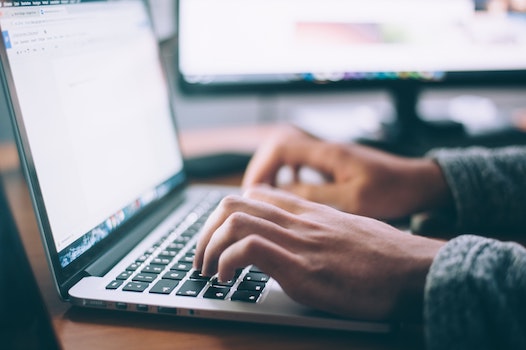 A person types on a laptop